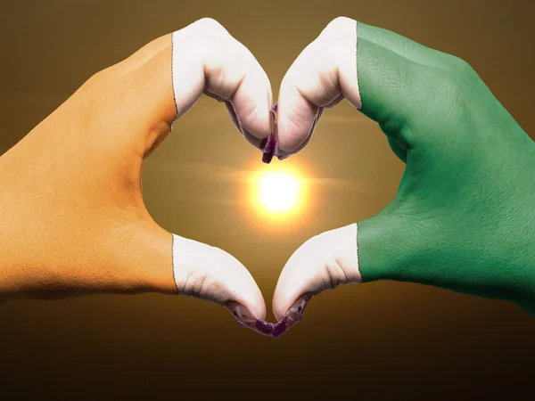 Heart and love gesture by hands colored in ivory coast flag duri — Stock Photo, Image