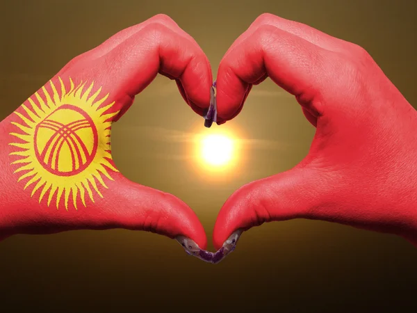 Coração e amor gesto por mãos coloridas no Quirguistão bandeira durin — Fotografia de Stock