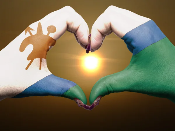 Heart and love gesture by hands colored in lesotho flag during b — Stock Photo, Image