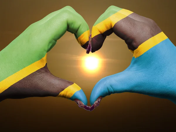 Жест любви и сердца руками, раскрашенными в танзанийский флаг во время — стоковое фото