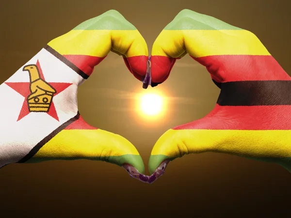 Heart and love gesture by hands colored in zimbabwe flag during — Stock Photo, Image