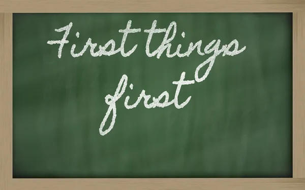 Expressão - Primeiras coisas primeiro - escrito em um blackboar da escola — Fotografia de Stock