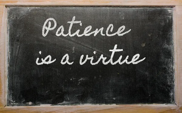 Expresión - La paciencia es una virtud - escrita en un blackbo escolar Imagen de stock