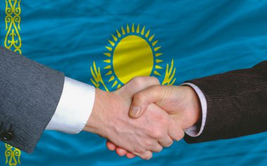 Businessmen handshake after good deal in front of kazakhstan fla clipart