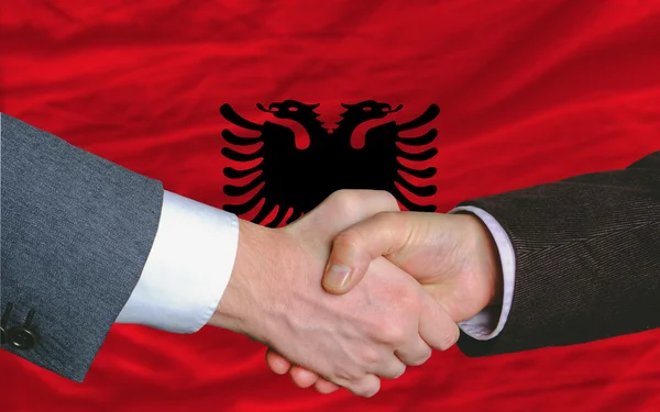 Affärsmän handskakning efter åtskilligt framför Albanien flagga — Stockfoto