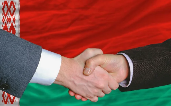 Uomini d'affari stretta di mano dopo un buon affare davanti alla bandiera bielorussa — Foto Stock