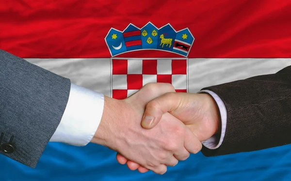 Business men handshakafterwards good deal in front of croatia flag — стоковое фото