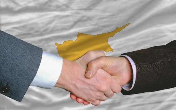 Empresários aperto de mão depois de um bom negócio na frente da bandeira cyprus — Fotografia de Stock