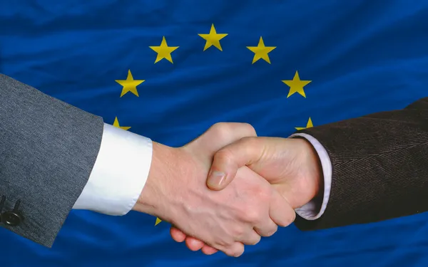 Işadamlarının karşılıklı sonra Avrupa bayrağı önünde iyi bir anlaşma — Stok fotoğraf