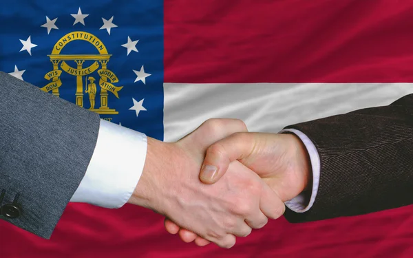 Podnikatelé handshake po hodně před vlajka Gruzie — Stock fotografie
