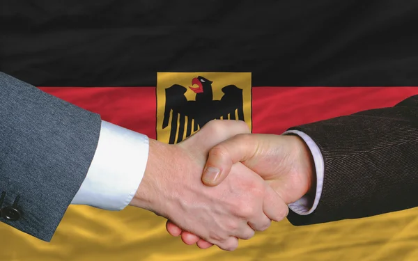 Empresarios apretón de manos después de un buen trato frente a la bandera de Alemania —  Fotos de Stock