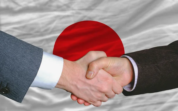 Biznesmeni uzgadniania po sporo przed flaga Japonii — Zdjęcie stockowe