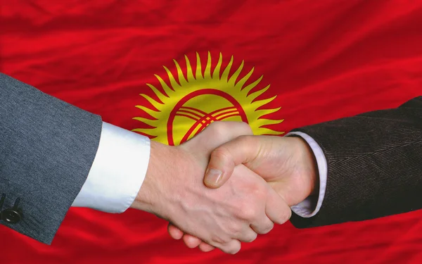 Деловые люди пожмут друг другу руки после выгодной сделки перед киргизстанским полем — стоковое фото