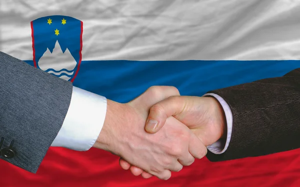 Unternehmer-Händedruck nach gutem Deal vor slowenischer Flagge — Stockfoto
