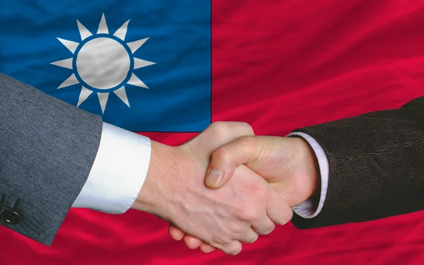 Деловые люди пожали друг другу руки после хорошей сделки перед флагом Тайваня — стоковое фото