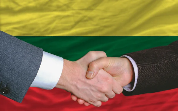 Uomini d'affari stretta di mano dopo un buon affare di fronte alla bandiera lituania — Foto Stock