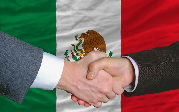 Uomini d'affari stretta di mano dopo un buon affare di fronte alla bandiera messicana — Foto Stock