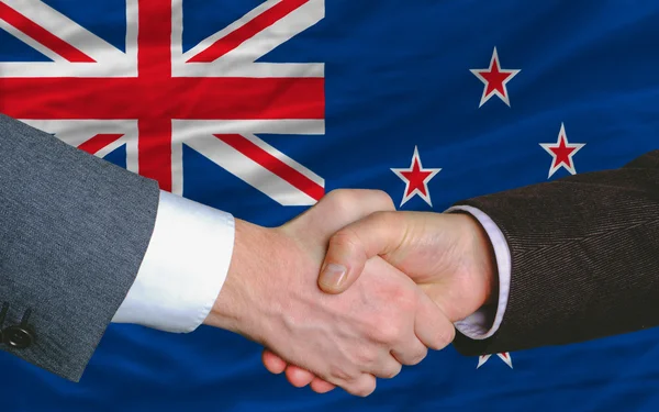 Empresarios apretón de manos después de un buen trato en frente de Nueva Zelanda fl — Foto de Stock
