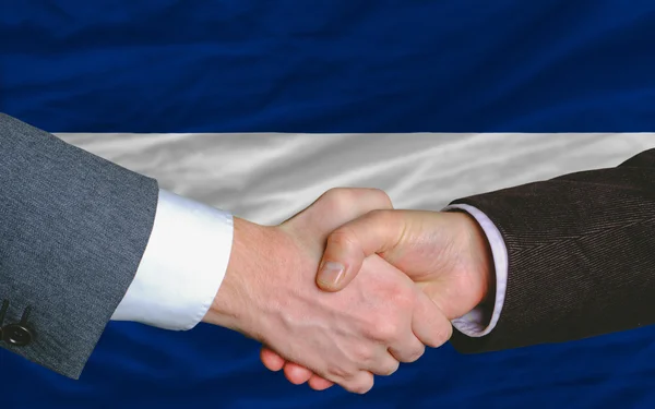 Podnikatelé handshake po hodně před Vlajka Nikaraguy — Stock fotografie