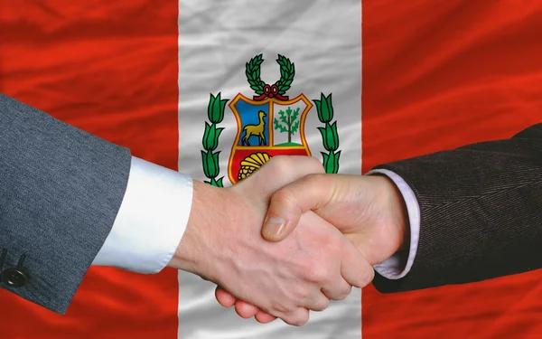 Businessmen handshake after good deal in front of peru flag — Stock Photo, Image