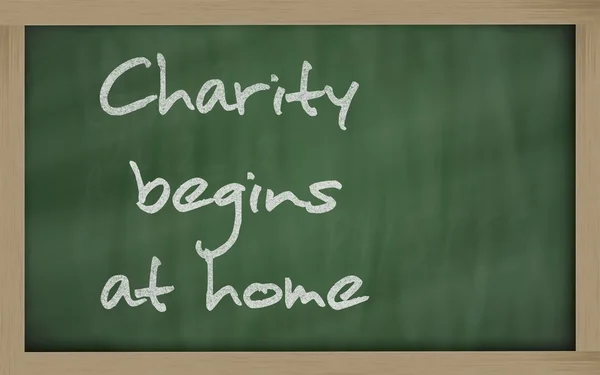 " Charity begins at home " written on a blackboard — Stock Photo, Image
