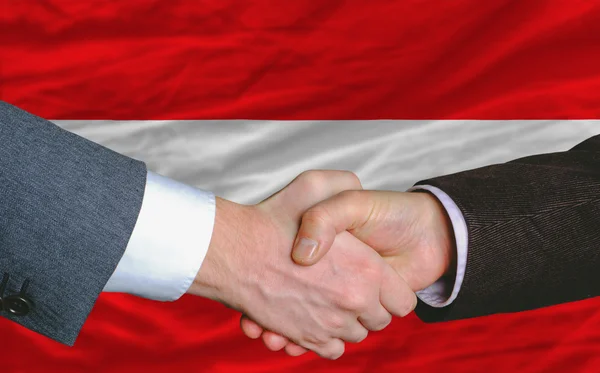 Uomini d'affari stretta di mano dopo un buon affare davanti alla bandiera austria — Foto Stock