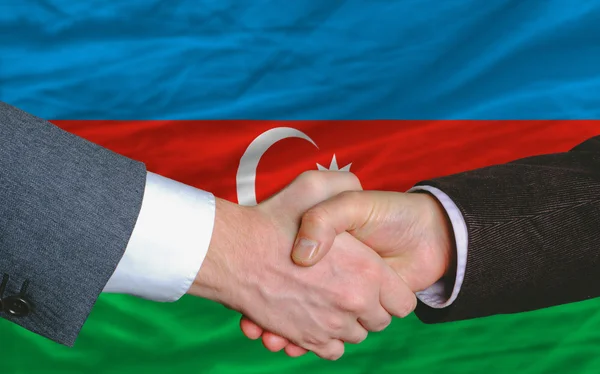 Empresarios apretón de manos después de un buen trato en frente de azerbaijan fla —  Fotos de Stock