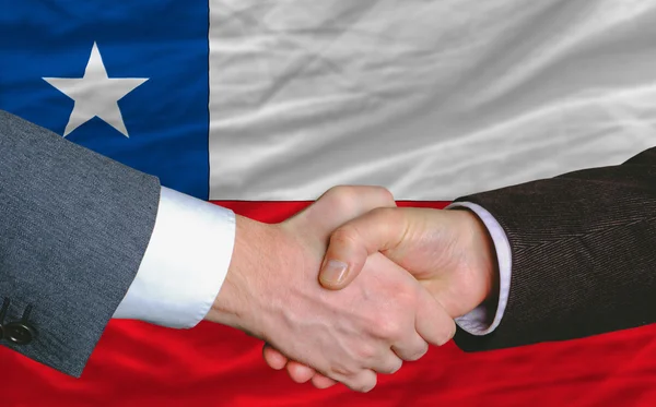 Business men handshakafterwards good deal in front of chile flag — стоковое фото