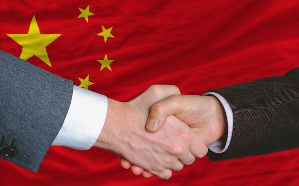 business men handshakafterwards good deal in front of china flag
