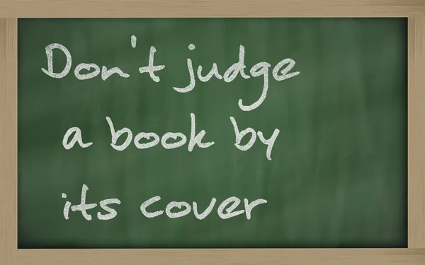 " Не судіть книгу за обкладинкою " написаною на дошці — стокове фото