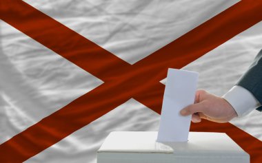 Man voting on elections in front of flag US state flag of alabam clipart