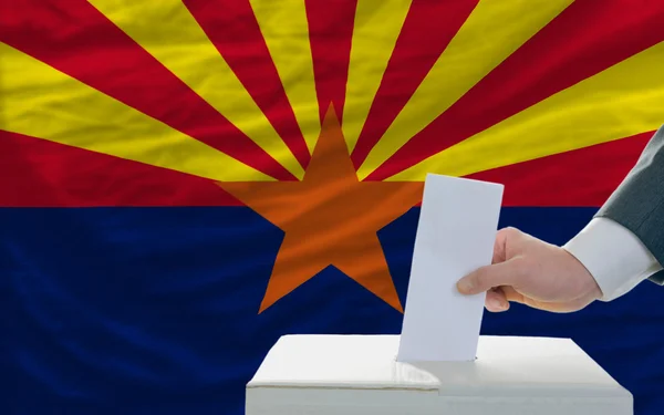 Man röstar om valet framför flagga oss statligt flagga arizon — Stockfoto