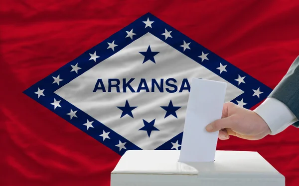 Hombre votando en las elecciones frente a bandera Bandera del estado de Estados Unidos de Arkans —  Fotos de Stock
