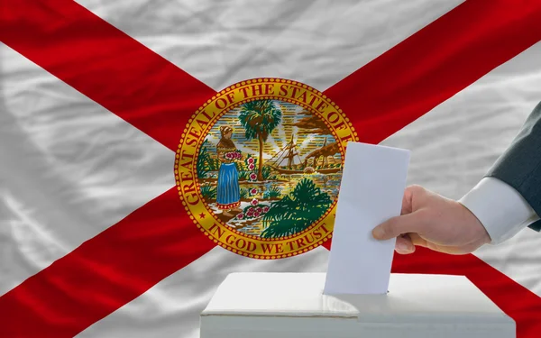 Man voting on elections in front of flag US state flag of florid — Stock Photo, Image