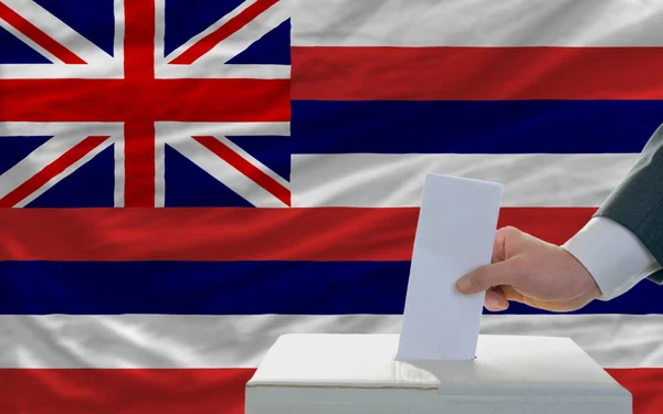 Homme votant pour les élections devant le drapeau de l'État américain drapeau d'Hawaï — Photo