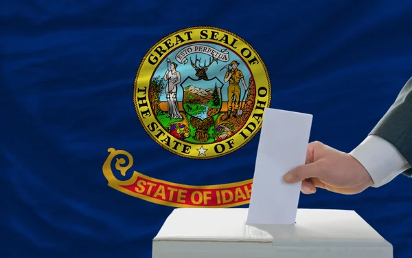 Mann bei der Stimmabgabe vor der Flagge des Staates Idaho — Stockfoto