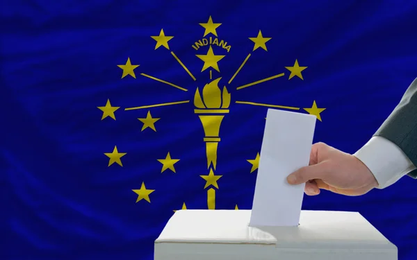 stock image Man voting on elections in front of flag US state flag of indian