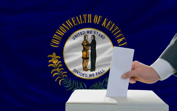 Man röstar om valet framför flagga oss statligt flagga kentuc — Stockfoto