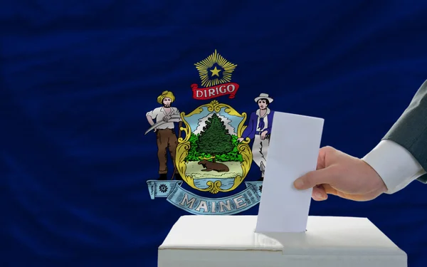 Uomo che vota per le elezioni davanti alla bandiera dello Stato americano del Maine — Foto Stock