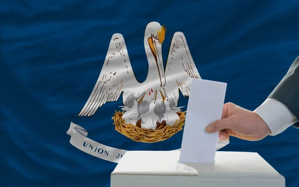 Man röstar om valet framför flagga oss statligt flagga louisi — Stockfoto