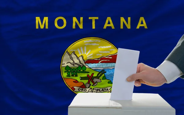 Mann bei der Abstimmung über Wahlen vor Flagge uns Staatsflagge von Montan — Stockfoto