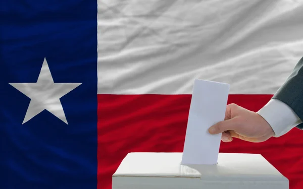 Man röstar om valet framför flagga oss statligt flagga texas — Stockfoto