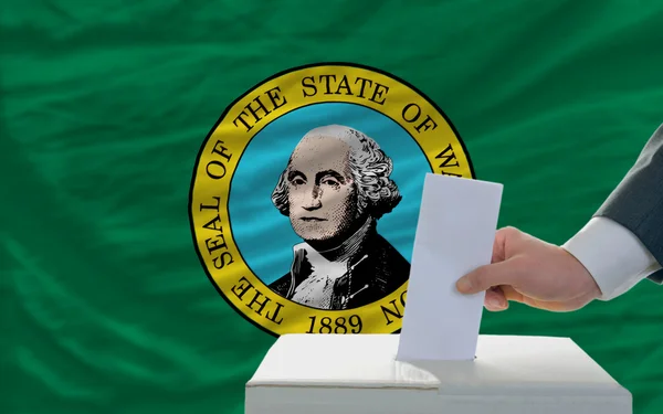 Hombre votando en las elecciones frente a bandera nos bandera del estado del oeste w — Stockfoto