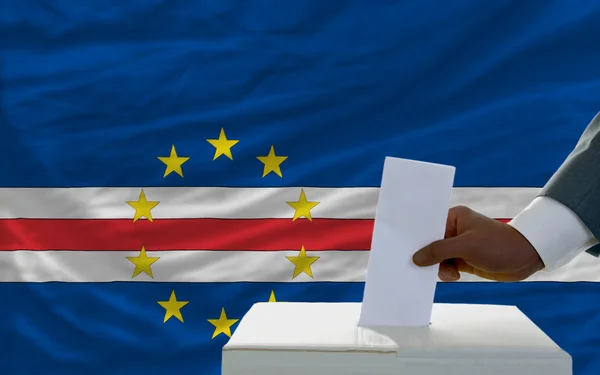 Mann bei der Stimmabgabe vor der Nationalflagge Capeverdes — Stockfoto
