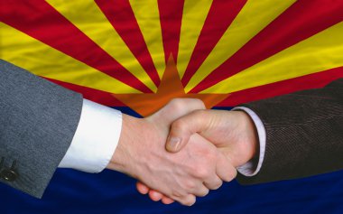 In front of american state flag of arizona two businessmen hands clipart