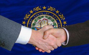 In front of american state flag of new hampshire two businessmen clipart