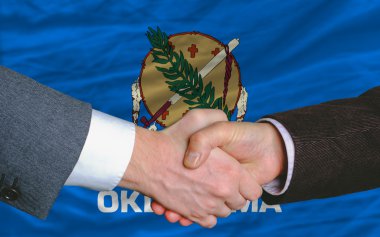 In front of american state flag of oklahoma two businessmen hand clipart