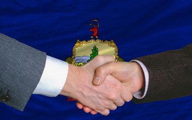 In front of american state flag of vermont two businessmen hands clipart