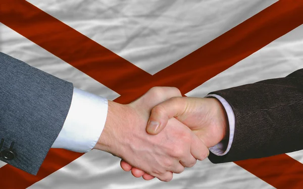 In front of american state flag of alabama two businessmen hands — Stock Photo, Image