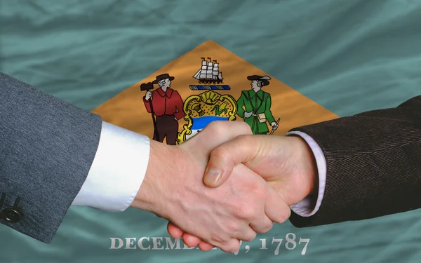 In front of american state flag of delaware two businessmen hand — Stock Photo, Image